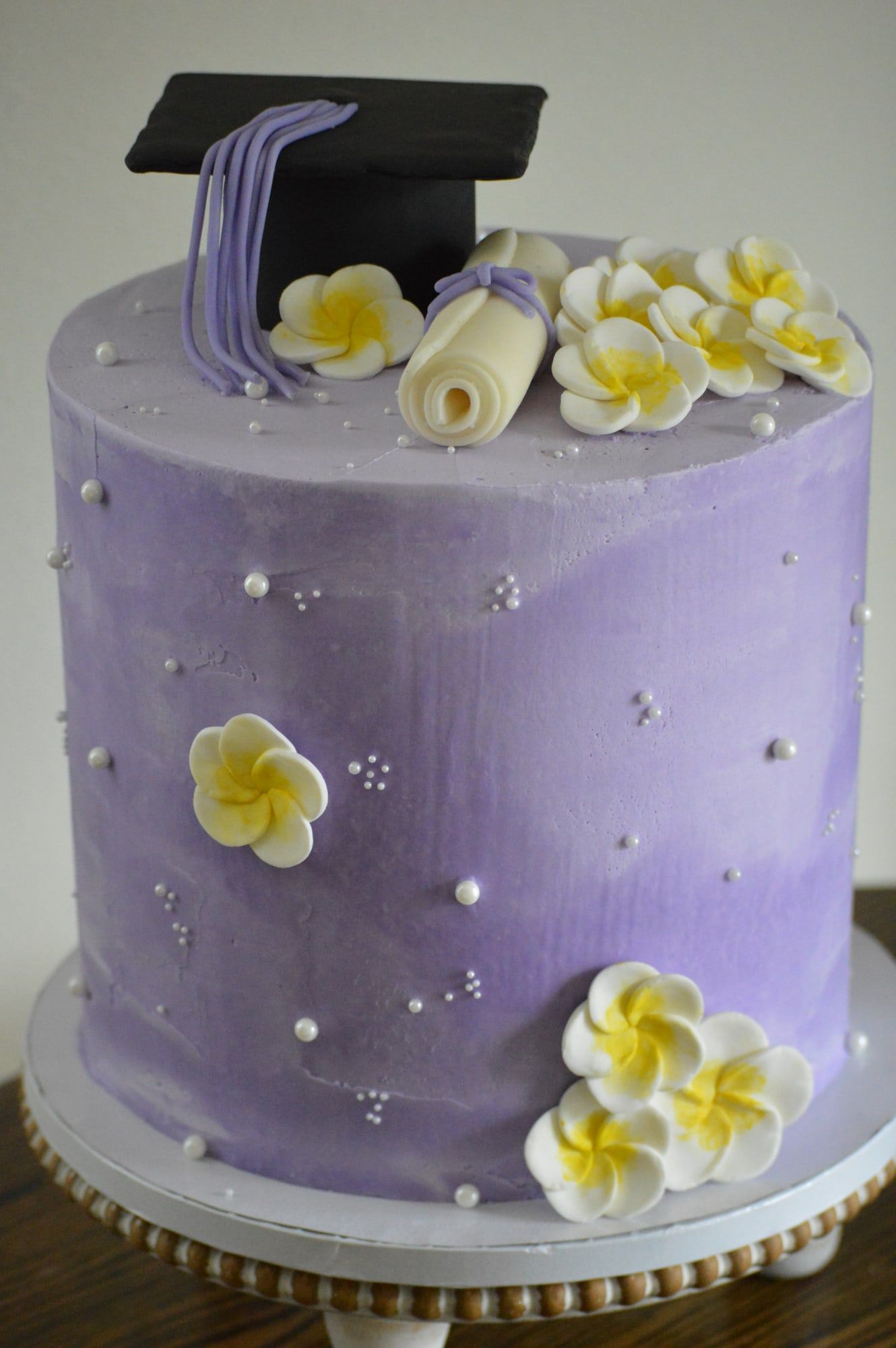 Lavender ombré cake with sugar frangipani flowers and scattered pearls