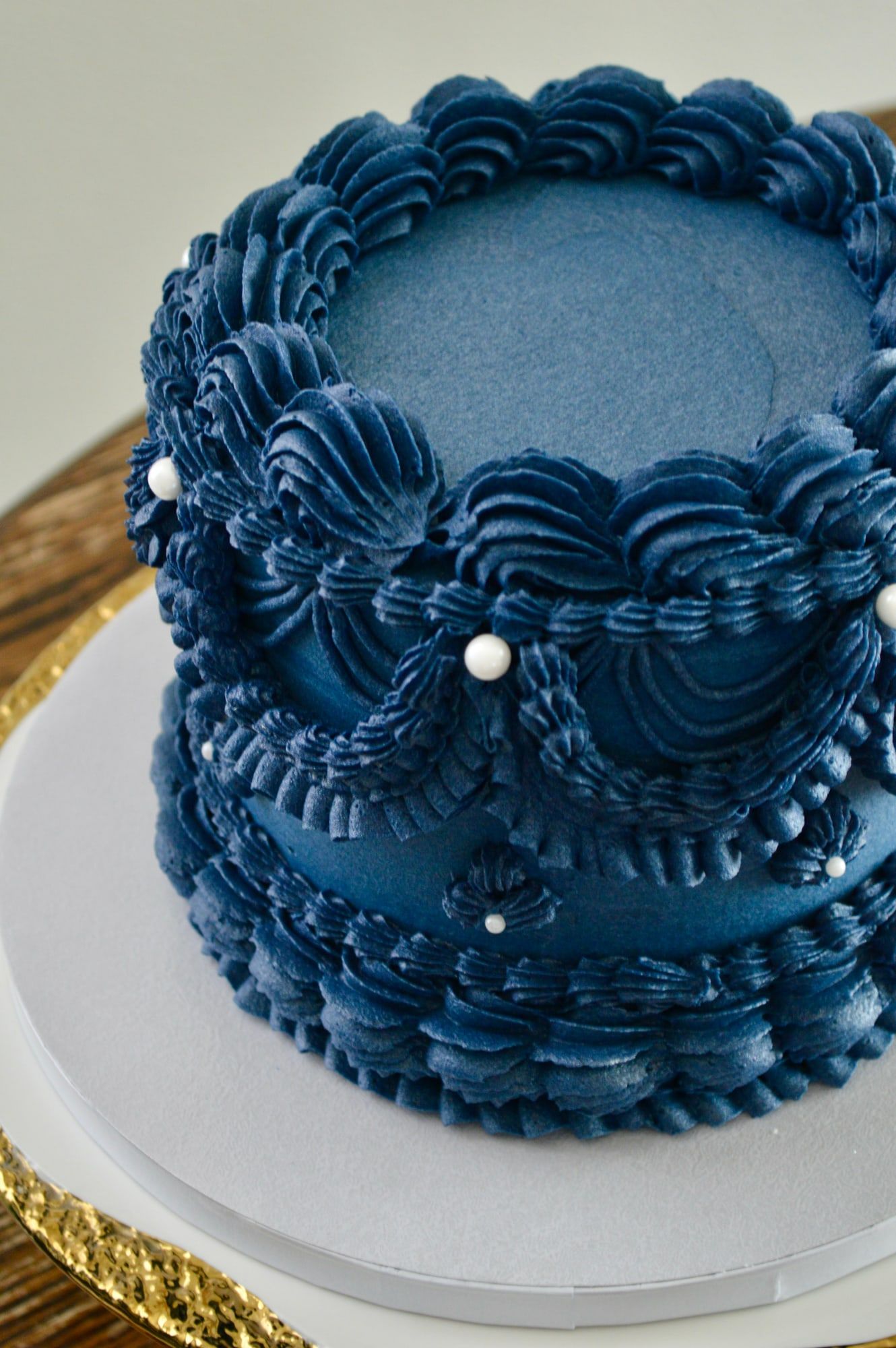 Close detail of navy vintage piping with scalloped ruffles and pearl accents