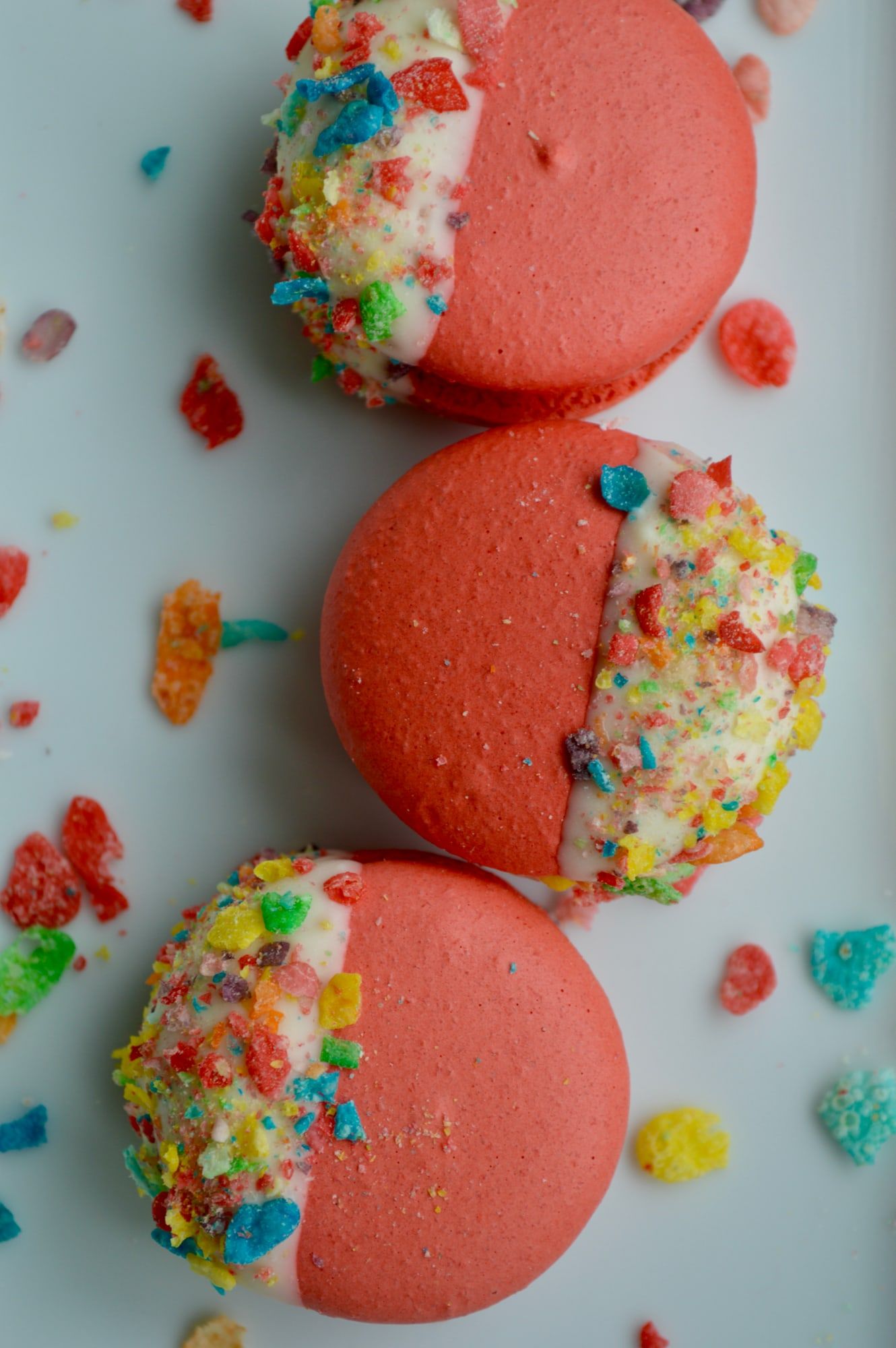 Pink macarons rolled in Fruity Pebbles cereal